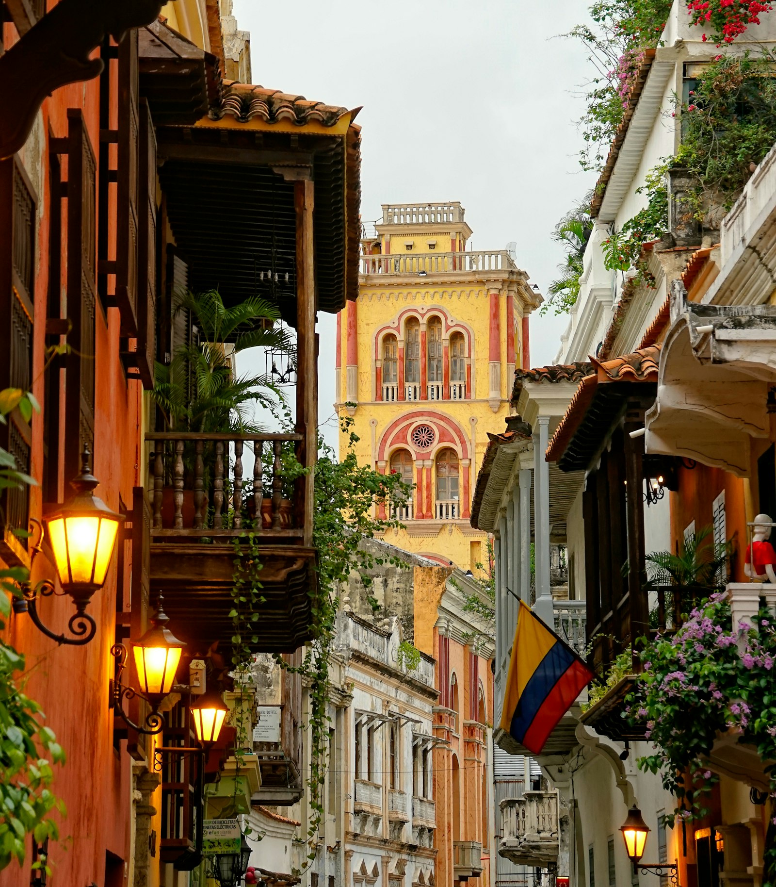 Calle colonial con balcones y campanario amarillo en el Centro Histórico de Cartagena