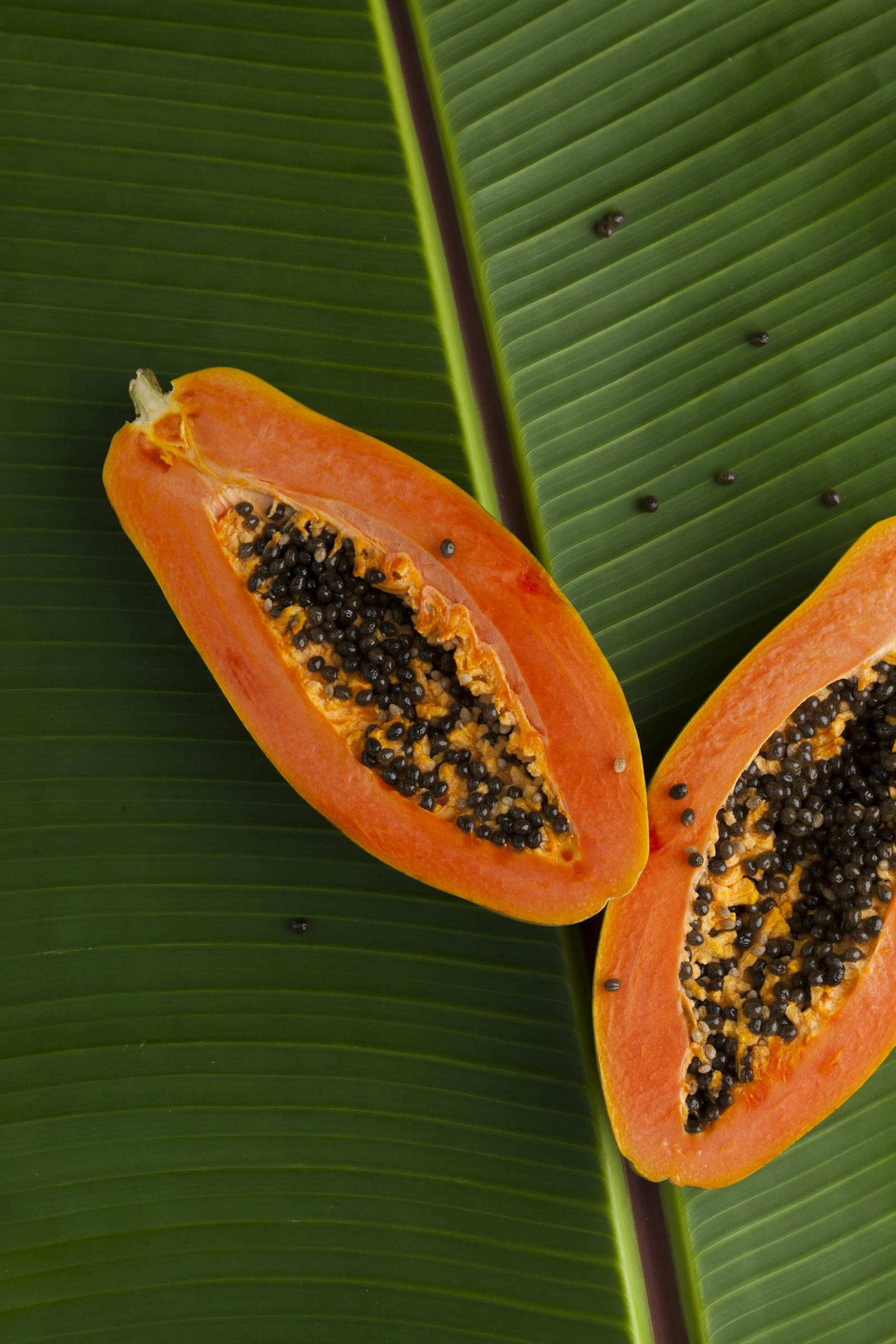 Papaya en rodajas sobre hoja de plátano, fruta con la que se preparan los caballitos
