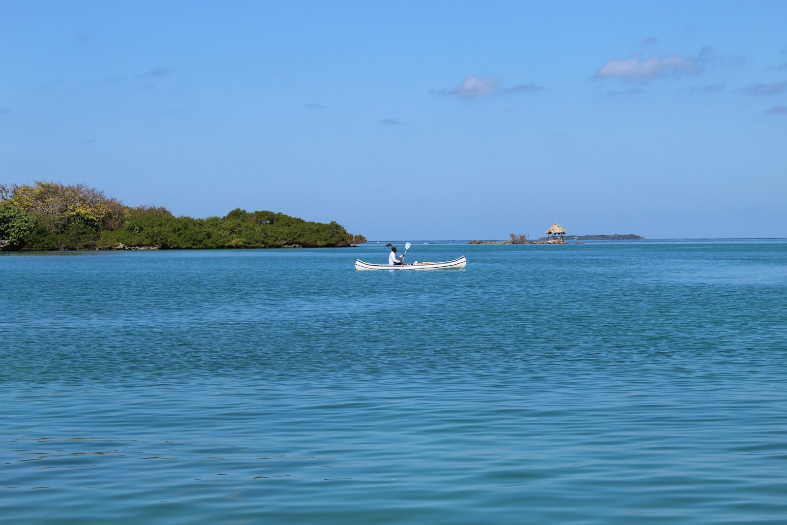 Lancha blanca navegando en aguas turquesa del mar Caribe rumbo a las islas
