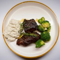 Plato de carne de res en salsa oscura, similar a la posta negra cartagenera
