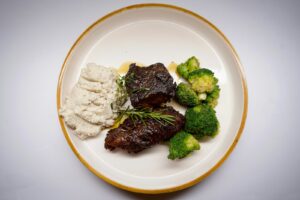 Plato de carne de res en salsa oscura, similar a la posta negra cartagenera