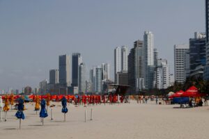 Playa urbana de Cartagena con sombrillas y edificios al fondo