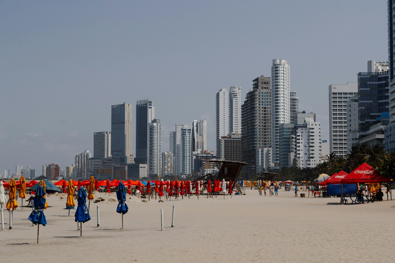 Stadtstrand in Cartagena mit Sonnenschirmen und Hochhäusern im Hintergrund
