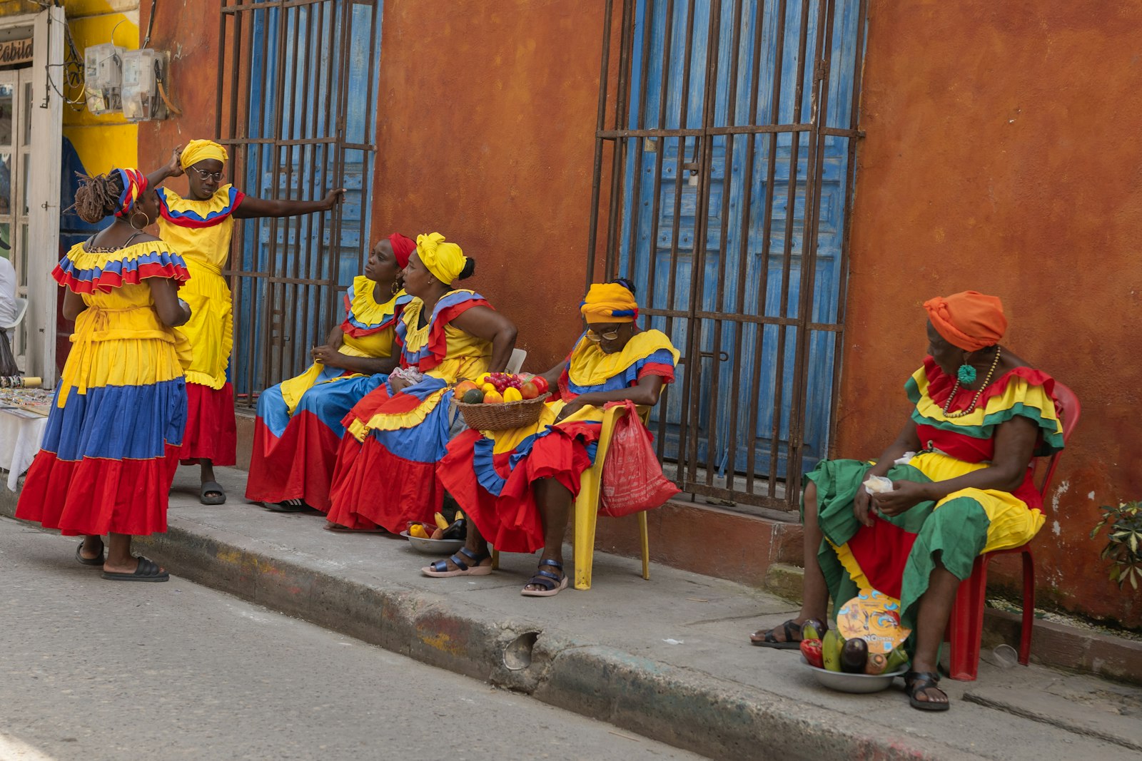 Vecinos sentados en la calle, escena de vida de barrio en Cartagena