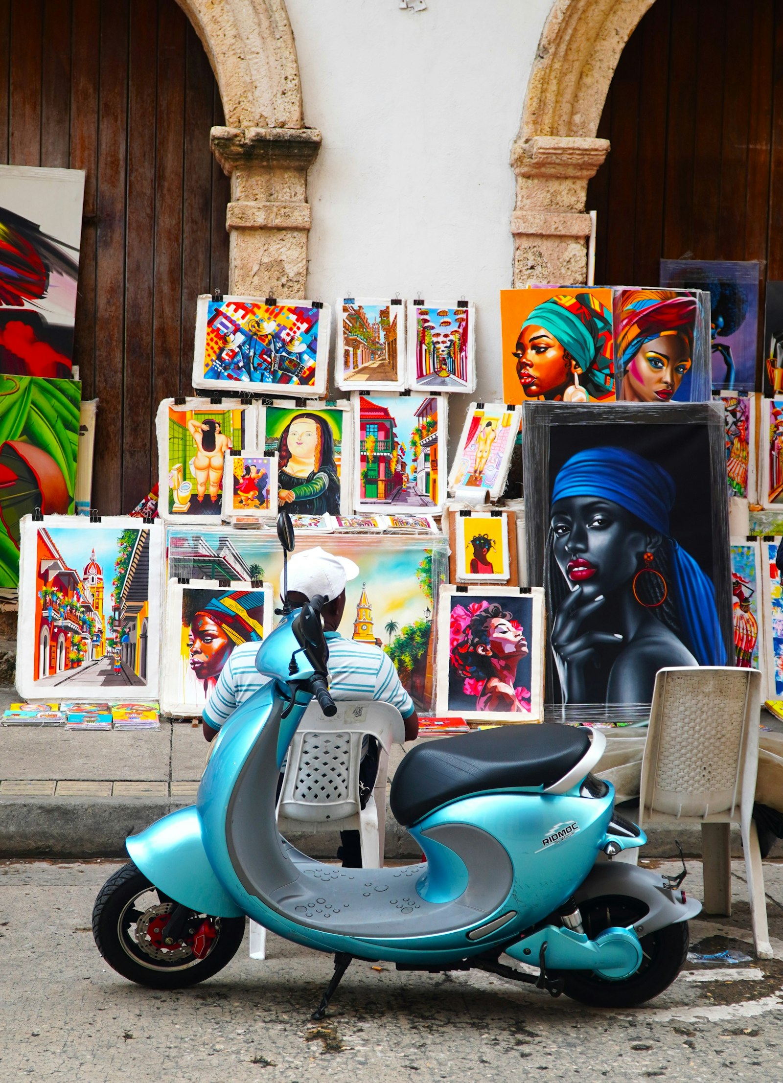Moto aparcada frente a una fachada con murales de arte urbano en Cartagena