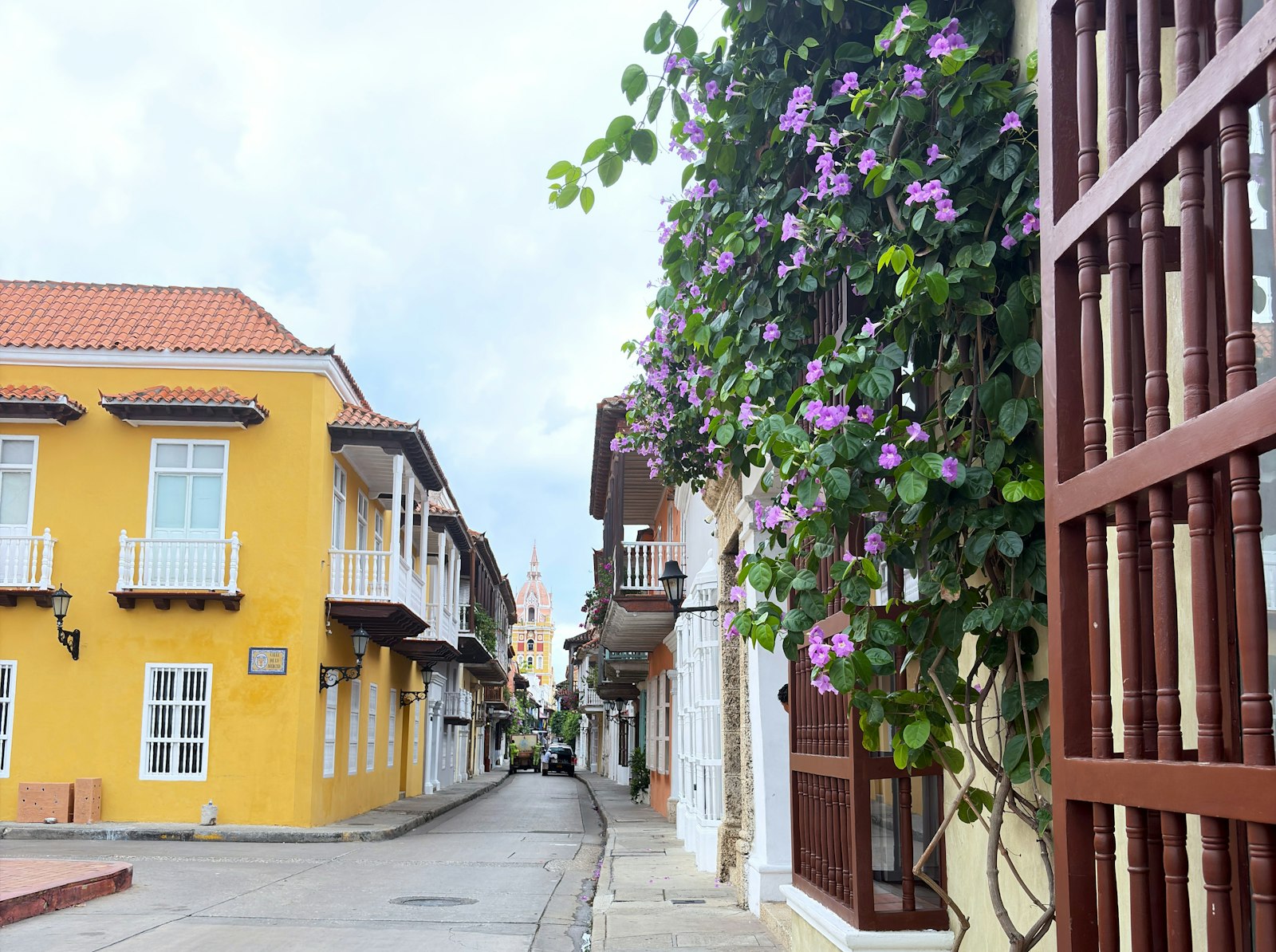 Calle colonial con fachadas de colores y buganvilias en la ciudad amurallada de Cartagena